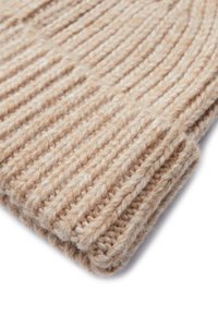 Gorro de punto beige hecho de lana gruesa, con una textura acanalada y un diseño de puño doblado para mayor calidez y comodidad.
