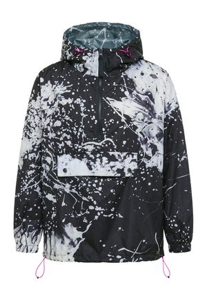 Černobílá větrovka s kapucí s puntíkovým vzorem, předním zipem, velkým kapsou s klopou na knoflíky, elastickými manžetami a růžovými šňůrkami.