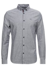 Szara koszula na guziki z długimi rękawami, o delikatnej fakturze, z małym logo na piersi. Czarne guziki i kontrastujący, wewnętrzny detal kołnierza.