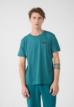 T-shirt turchese a maniche corte con scollatura rotonda; presenta un piccolo logo in tonalità più scure nella zona del petto sinistro; tessuto di cotone morbido.