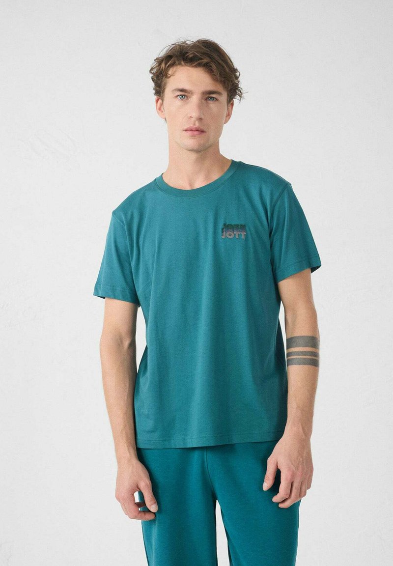 T-shirt turchese a maniche corte con scollatura rotonda; presenta un piccolo logo in tonalità più scure nella zona del petto sinistro; tessuto di cotone morbido.
