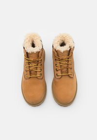 Stivaletti in pelle marrone con fodera in pelliccia sintetica, punta arrotondata, dettagli delle stringhe gialli e rossi, e suola in gomma testurizzata.