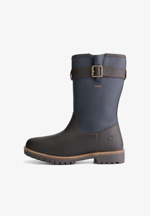 Bruine en marineblauwe waterdichte kniehoge laarzen met een gestructureerd oppervlak, een gespaccent en een stevige rubberen zool met profiel voor grip.