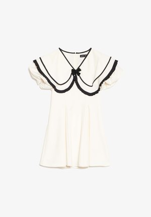 Vestido crema con cuello grande con borde negro, bordes de volantes negros, mangas cortas abullonadas y un pequeño lazo negro en el escote.