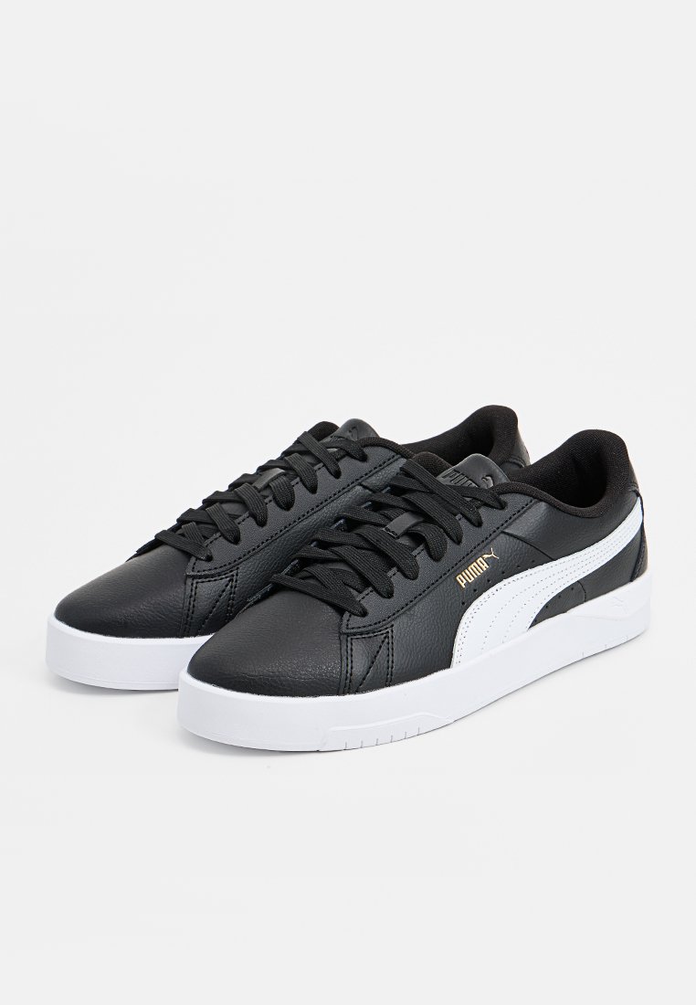Chaussures de sport en synthétique noir avec une bande blanche Puma, lacets plats et semelle en caoutchouc blanche. Détails subtils du logo doré.