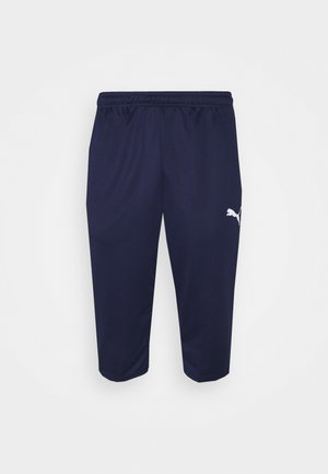 Navy athletic pants made of lightweight fabric. Features an elastic waistband and a white logo on the left thigh. Ankle length design.
