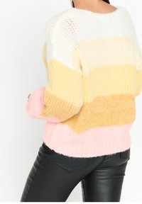 Stickad tröja med horisontella ränder i vitt, gult, ljusorange och rosa. Tjock textur, avslappnad passform samt ribbad nederkant och ärmslut.
