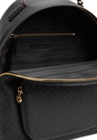 Μαύρο σακίδιο πλάτης με ανάγλυφο μοτίβο λογότυπου, χρυσά φερμουάρ και εσωτερικό με τσέπη με φερμουάρ και επένδυση με το λογότυπο της μάρκας.