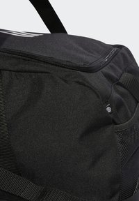 Borsa a duffle nera realizzata in tessuto testurizzato, con chiusura a zip, tasca laterale in rete e tracolla regolabile.