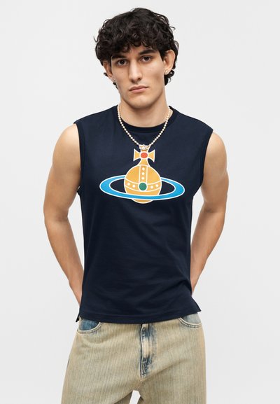 Μπλε σκούρο αμάνικο t-shirt με πολύχρωμο κοσμικό σχέδιο σε πορτοκαλί, πράσινο και μπλε. Απαλό βαμβακερό ύφασμα, χαλαρή εφαρμογή. Φθαρμένο ανοιχτό τζιν.