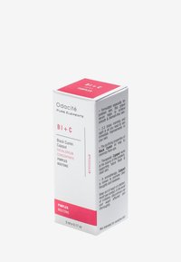 Boîte de sérum facial Odacité Bi+C, blanche avec des accents roses, de forme carrée, capacité de 5 ml, et détails sur les ingrédients et l'utilisation.