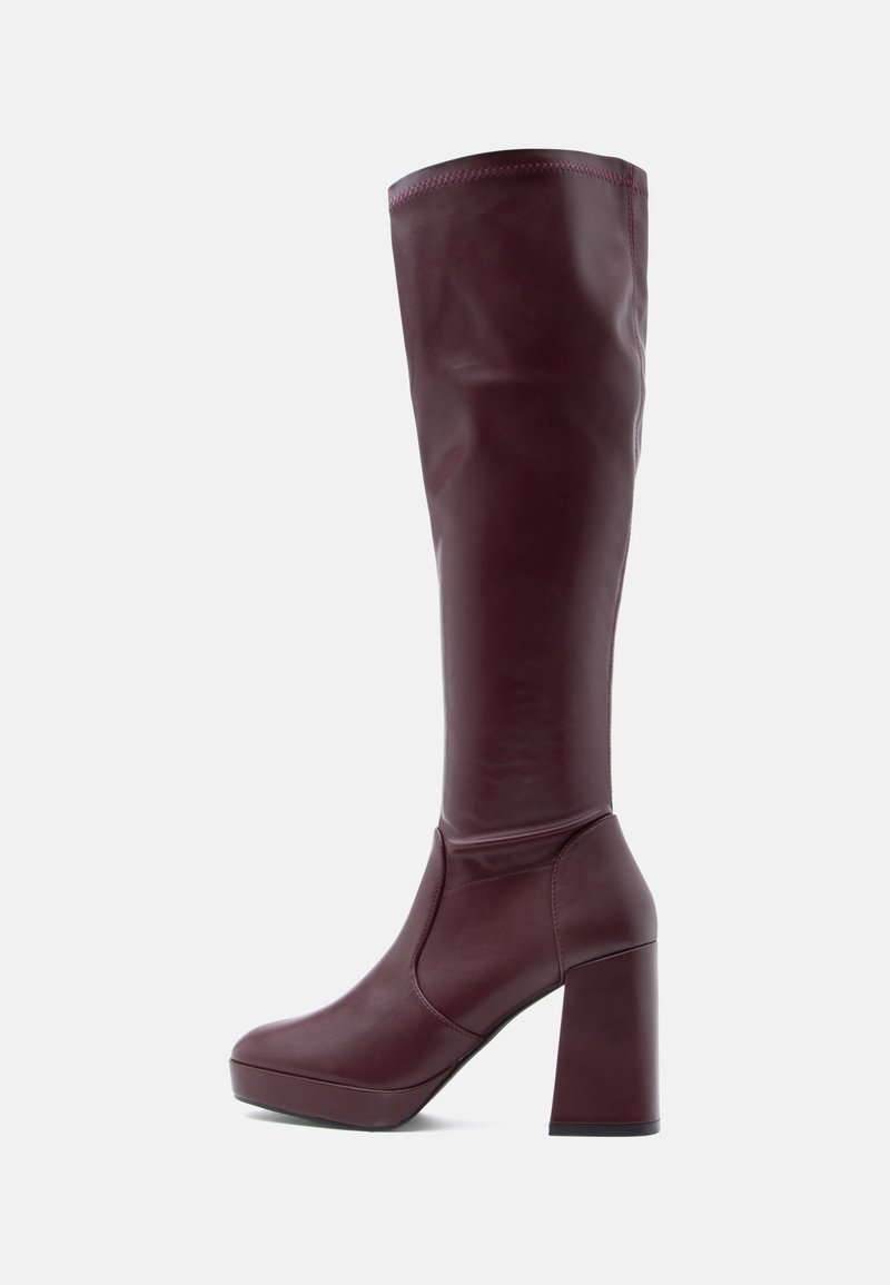 Botas hasta la rodilla color granate hechas de cuero liso, con un tacón grueso de bloque y una silueta estilizada. La parte superior tiene detalles mínimos de costura.