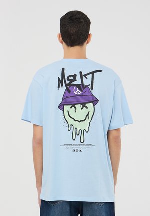 T-shirt in cotone azzurro cielo con una grafica di una faccina sorridente verde che si scioglie, indossante un cappello a secchiello viola e con la scritta nera "MELT" sul retro.