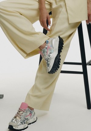 Zapatillas chunky con una mezcla de lentejuelas plateadas y acentos en tonos pastel. Presentan una lengüeta rosa, upper texturizado y suela de goma negra.