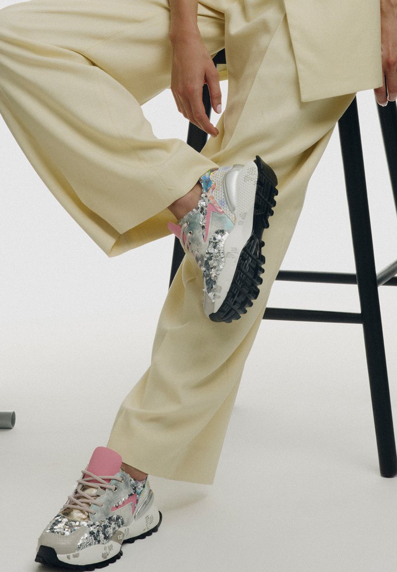 Zapatillas chunky con una mezcla de lentejuelas plateadas y acentos en tonos pastel. Presentan una lengüeta rosa, upper texturizado y suela de goma negra.