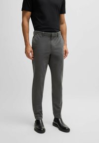 Grå bomullsblandning byxor med skräddarsydd passform, med flat front, sidofickor och knappstängning, kombinerat med svarta ankelstövlar.