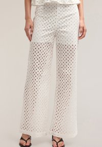 Witte, wijde broek met een verfijnd diamant patroon. Lichtgewicht stof met een gladde textuur en een ontspannen pasvorm.