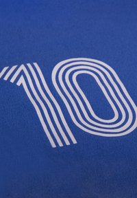 Blauwe stof met een opvallend wit "10" ontwerp, samengesteld uit gelaagde gebogen lijnen. De textuur lijkt soepel en licht geborsteld.