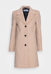 Manteau long en mélange de laine beige avec trois boutons noirs, col à revers large et poches latérales, présenté sur un fond blanc.