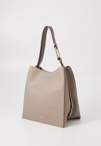 Sac à main en cuir beige avec une finition texturée, grand haut ouvert et une seule bandoulière. Présente des détails en matériel couleur or.