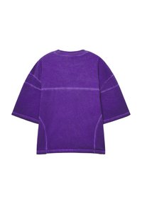 T-shirt viola oversize con maniche corte, caratterizzato da un tessuto testurizzato e linee di cucitura a contrasto lungo la schiena.