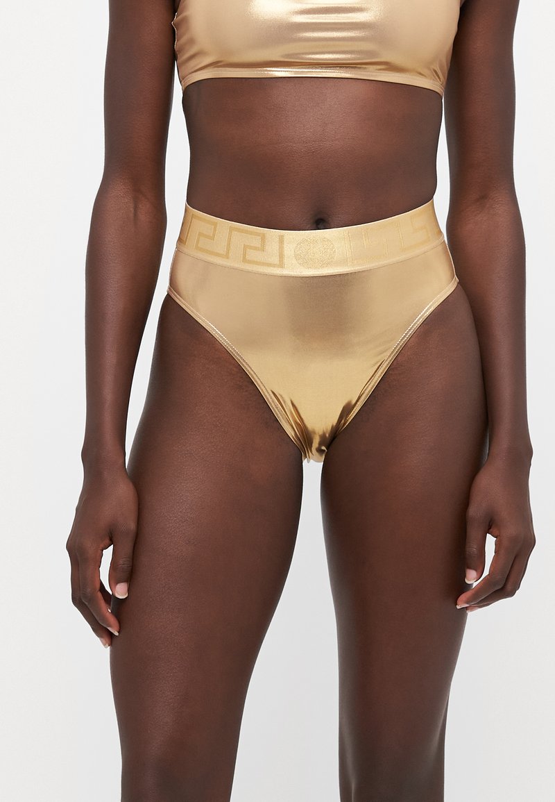 Gull metalliske høyde bikinibukser med en glatt tekstur og et dekorativt mønstret midjebånd. Stylet med en matchende crop-top.