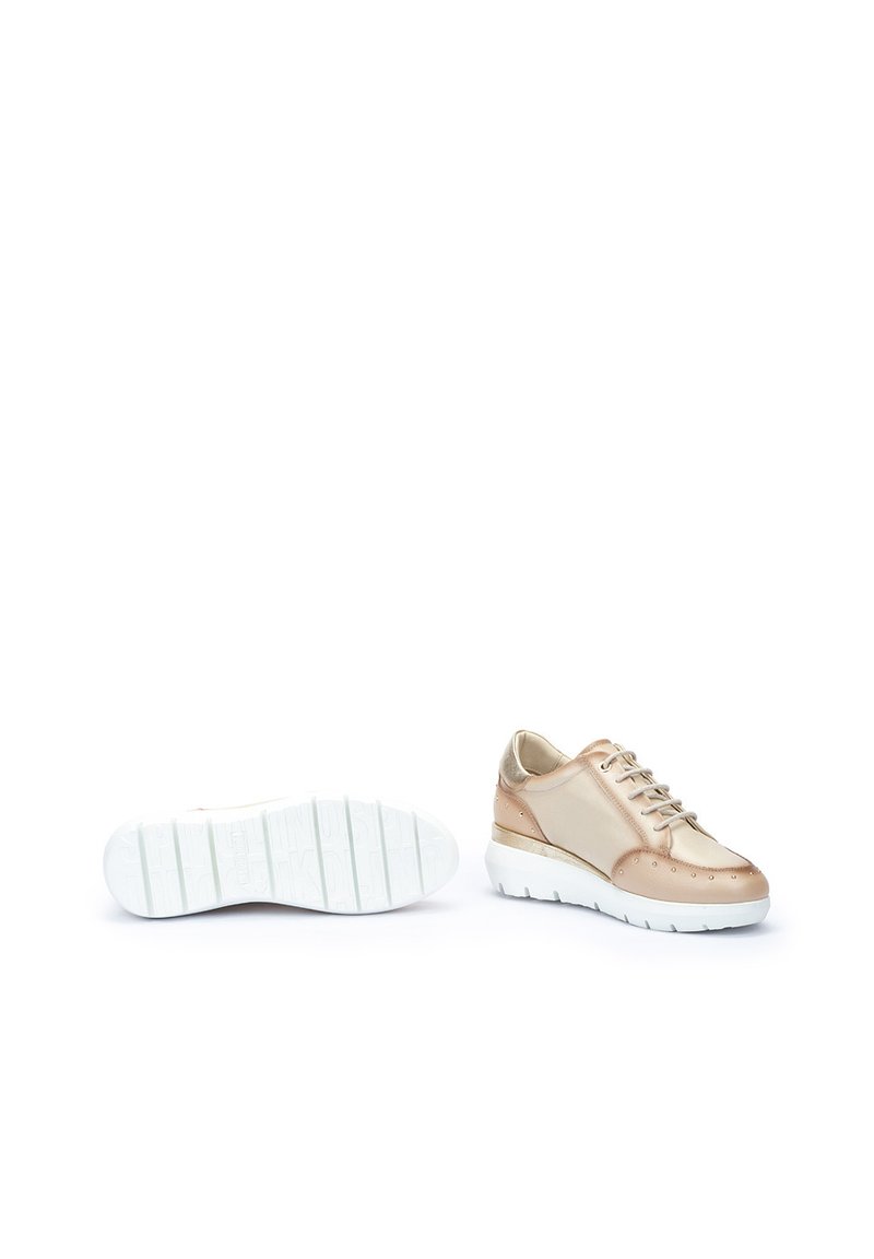 Zapatillas con un upper metálico rosa dorado brillante y suela de goma blanca, con un acabado texturizado y punta redondeada. Diseño con cordones.