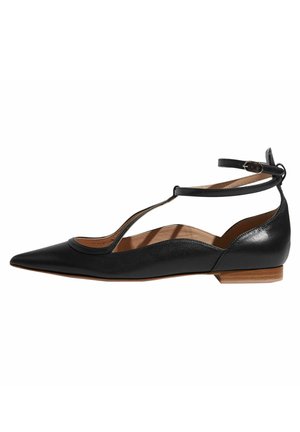 Black pointed-toe flat shoe with ankle strap and T-strap design, tan inner lining, and low wooden heel.