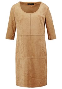 Robe en daim beige longueur genou avec manches trois-quarts et col rond, avec des coutures apparentes à l'avant.