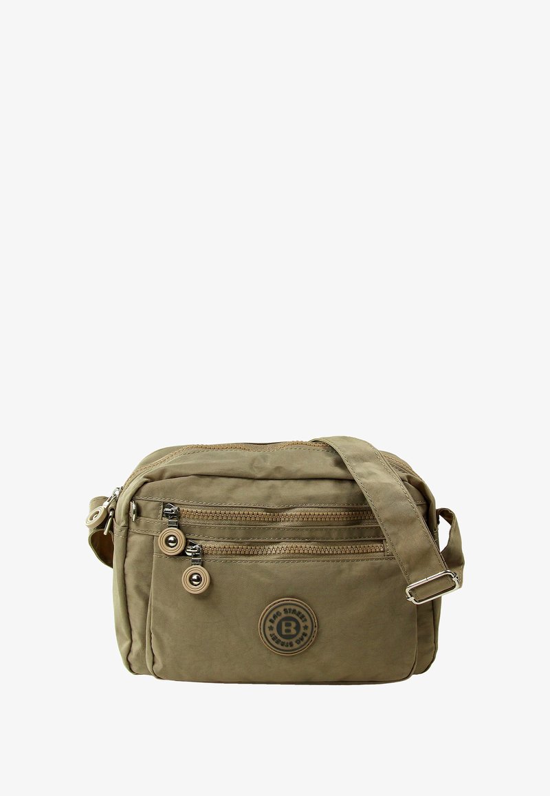 Khakifarbene Umhängetasche aus weichem Stoff mit verstellbarem Tragegurt, ausgestattet mit zwei Reißverschluss-Fronttaschen und einem runden Logo-Patch.