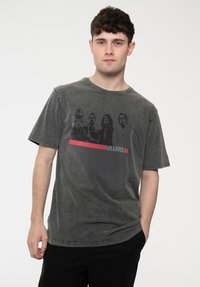 Dark gray cotton t-shirt featuring a faded graphic print of four figures and the word "KILLERS" in red beneath. Short sleeves and crew neck.