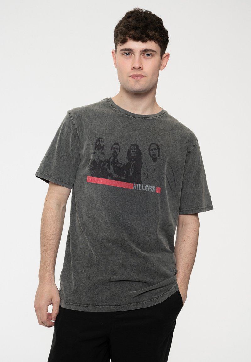 Dark gray cotton t-shirt featuring a faded graphic print of four figures and the word "KILLERS" in red beneath. Short sleeves and crew neck.