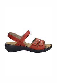 Rode leren sandaal met twee klittenbandsluitingen, een open neus en een gebogen zwarte zool. Beschikt over een gevoerde inlegzool voor comfort.