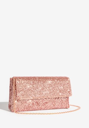 Lille rektangulær clutch pung dækket af skinnende roseguld glitter med en tynd guldkæde strop på hvid baggrund.