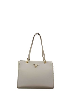 Borsa in pelle beige chiaro con doppie tracolle, occhielli dorati, piccolo fiocco e ciondolo a forma di cuore su sfondo semplice.