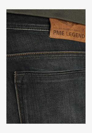 Jeans in denim blu scuro con finitura testurizzata. Presentano cuciture arancioni e un'etichetta in pelle marrone con la scritta "PME Legend" sulla cintura.