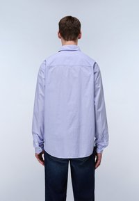 Light purple long-sleeve shirt with a button-down collar and back yoke, paired with dark jeans. The fabric appears smooth with a subtle texture.