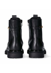 Schwarze Lederstiefeletten mit glatter Oberfläche, hinteren Reißverschlüssen, Akzenten in goldfarbener Hardware und robusten schwarzen Gummisohlen.