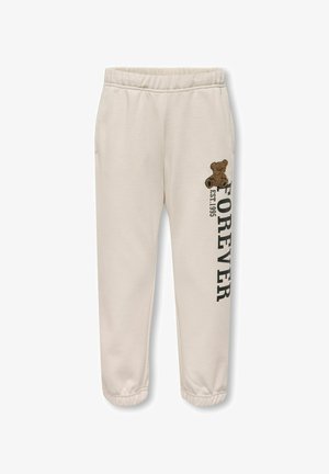 Beige joggingbukser med elastisk talje og manchetter, dekoreret med en lille brun bamse og vertikal tekst "FOREVER EST 1995" på benet.