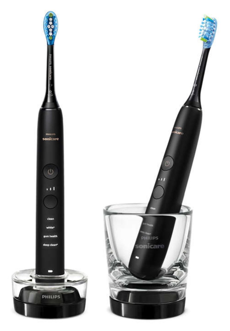 Spazzolino elettrico nero con setole blu e pulsanti sul manico, esposto in un portaspazzolino in vetro trasparente. Include una base di ricarica.