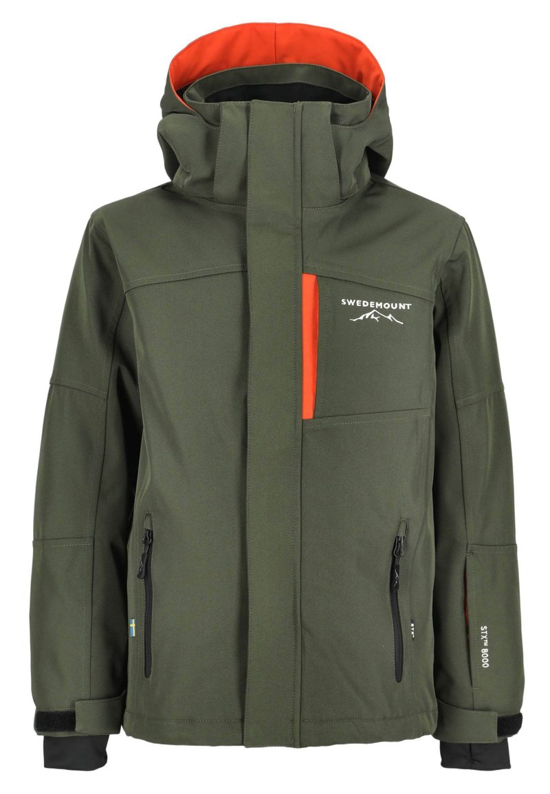 Vihreä pehmeäkuorinen takki, jossa on oranssi vuori, useita taskuja, vetoketjuloituksia ja huppu. Siinä on mustia yksityiskohtia ja logotunnuksia.