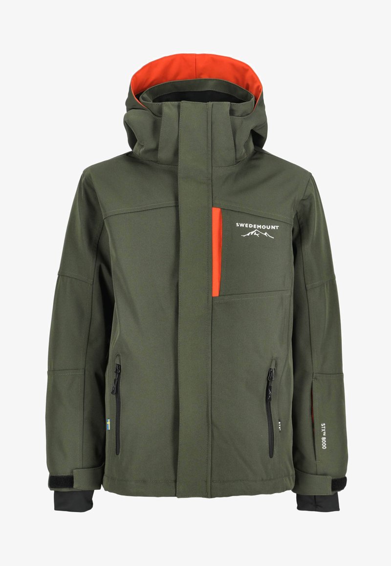 Vihreä pehmeäkuorinen takki, jossa on oranssi vuori, useita taskuja, vetoketjuloituksia ja huppu. Siinä on mustia yksityiskohtia ja logotunnuksia.