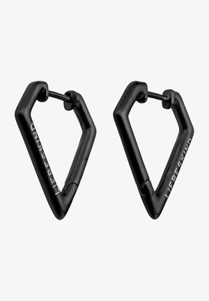 Zwarte metalen hangende oorbellen in de vorm van omgekeerde driehoeken, met een gladde textuur en een gegraveerde merNaam aan één kant.