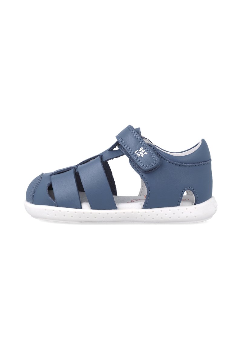 Sandal in pelle blu con cinturini elasticizzati, lati aperti e suola in gomma bianca e testurizzata. Presenta un chiusura a strappo per una facile regolazione.
