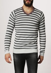 Grå och vitrandig tröja med långa ärmar, V-ringning och en vinröd detalj på kragen. Ribbad mudd och fåll för en åtsittande stil.