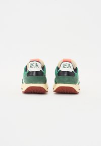 Green and navy suede sneakers with a beige midsole, rubber outsole, and red heel accents. Features a logo on the heel tab.