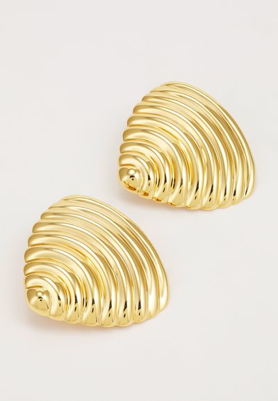 Boucles d'oreilles en métal doré avec un design ondulé et nervuré, évoquant une coquille. Surface lisse et brillante avec une forme triangulaire aux bords arrondis.