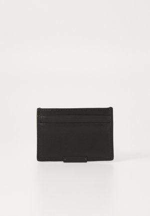 Sort læder kortholder med fire kortspor og et centralt rum, med minimal syning og en metallisk detalje foran.