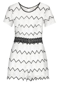 Vit spetsromper med ett svängd mönster i svart. Korta ärmar, rund halsringning och en figurnära midja som accentueras av ett svart spetsband.