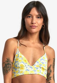 Bralette floreale realizzato in tessuto a coste giallo, blu e bianco. Presenta una scollatura a V profonda e spalline sottili regolabili.